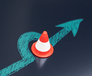 stock image of arrow pointing around a traffic cone